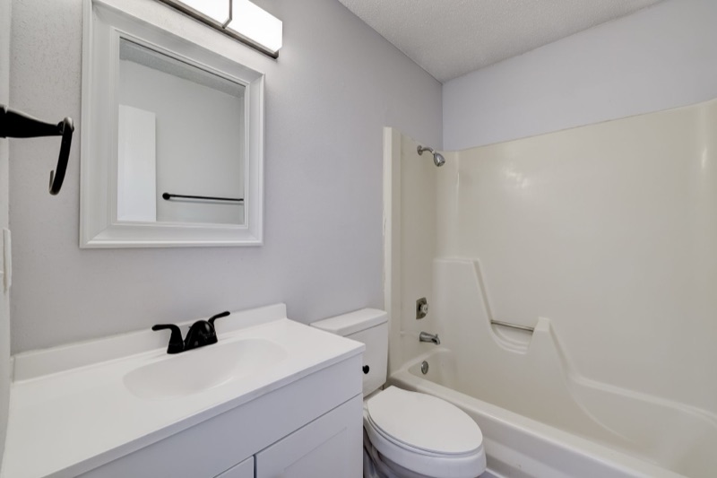 Renovated bathroom with tiled tub surround at The Hampton Meadows