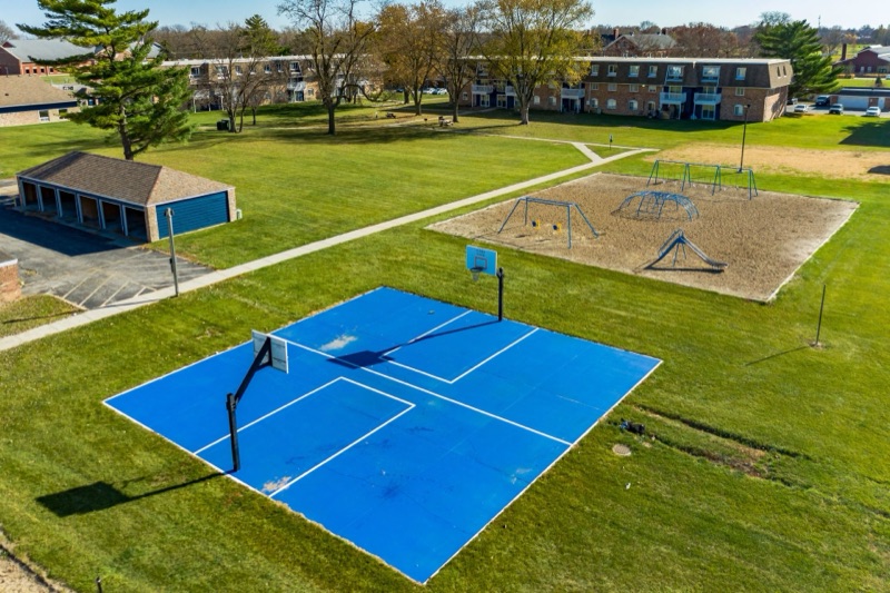 Aerial view of the on-site basketball court and playground at The Hampton Meadows