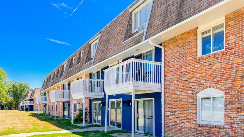 Apartment building exterior with white and navy balconies at The Hampton Meadows