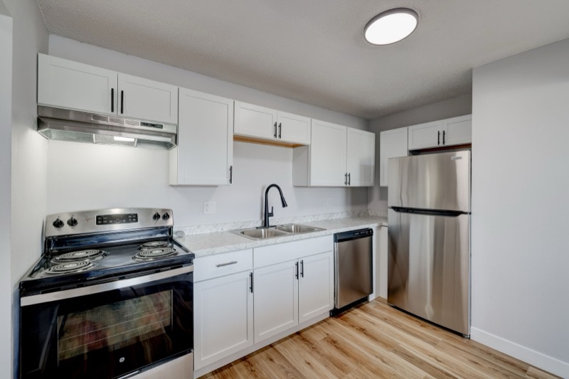 Renovated kitchen with white shaker cabinets and stainless appliances at The Hampton Meadows